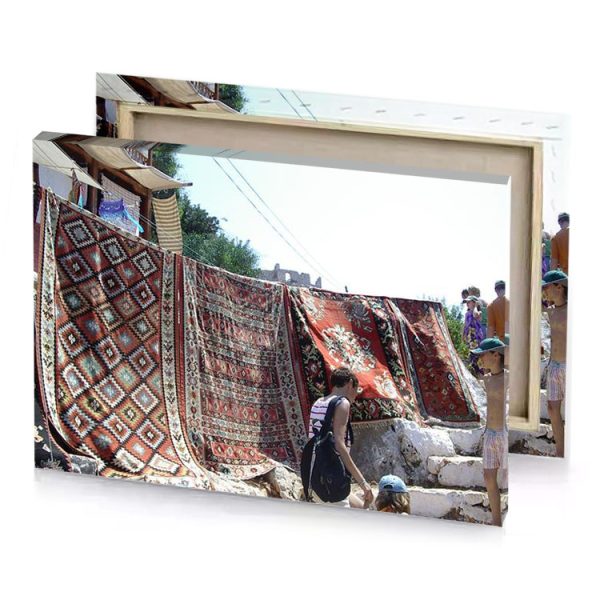 a group of people standing around pile rugs garnet canvas - Image 4