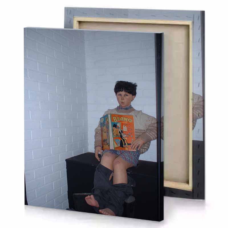 a boy sitting on chair reading book manatee canvas