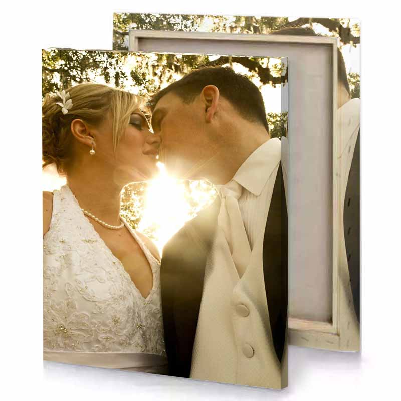 a bride and groom kissing in front of tree tan canvas