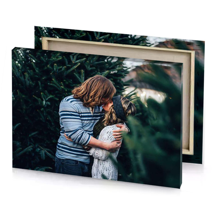 a couple hugging in front of christmas tree manatee canvas