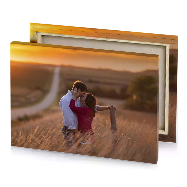 a couple kissing in field at sunset garnet canvas