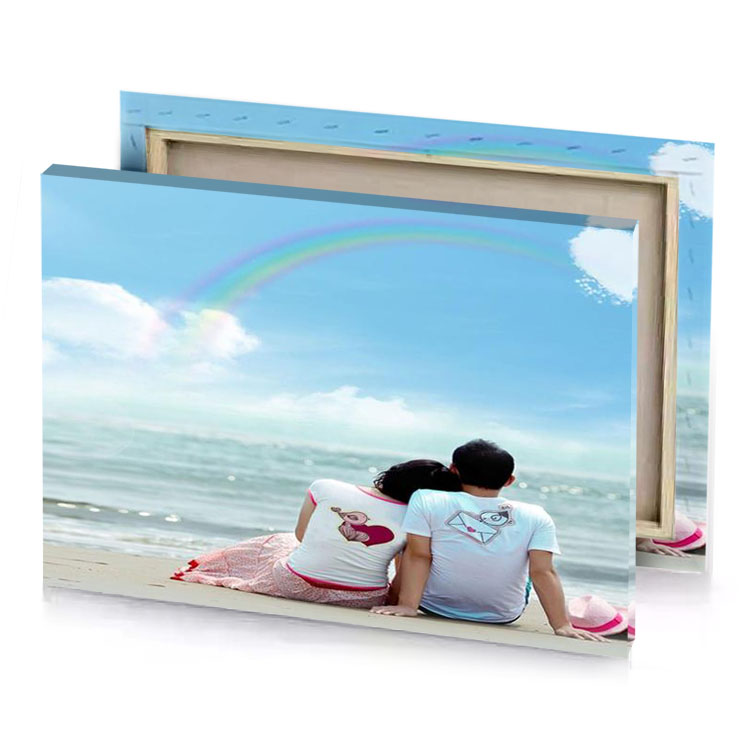 a couple sitting on the beach looking at ocean sky blue canvas