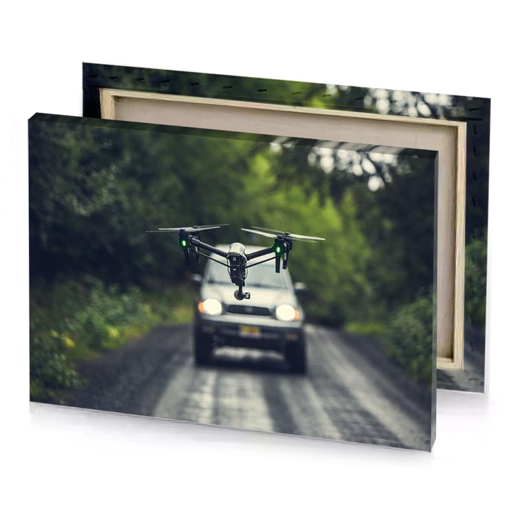 a drone flying over car on road fern green canvas