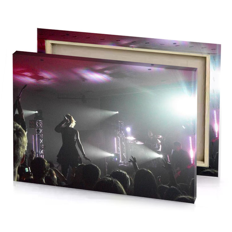 a group of people on stage with their hands up gray canvas