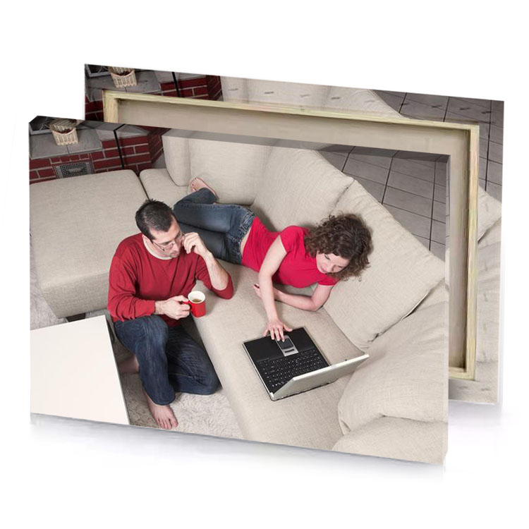 a man and woman sitting on couch with laptop brown canvas
