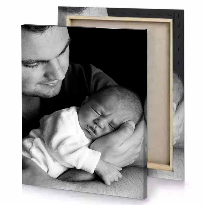 a man holding baby in his arms black canvas