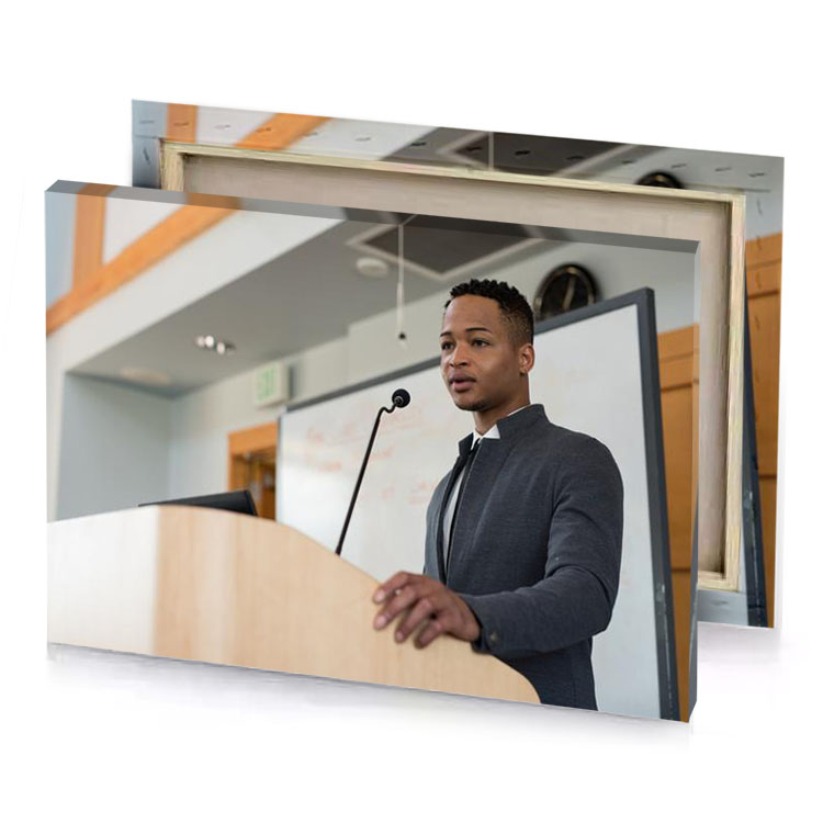 a man in suit standing at podium tan canvas