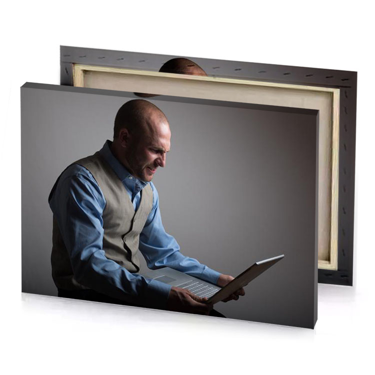 a man sitting down with laptop computer gray canvas