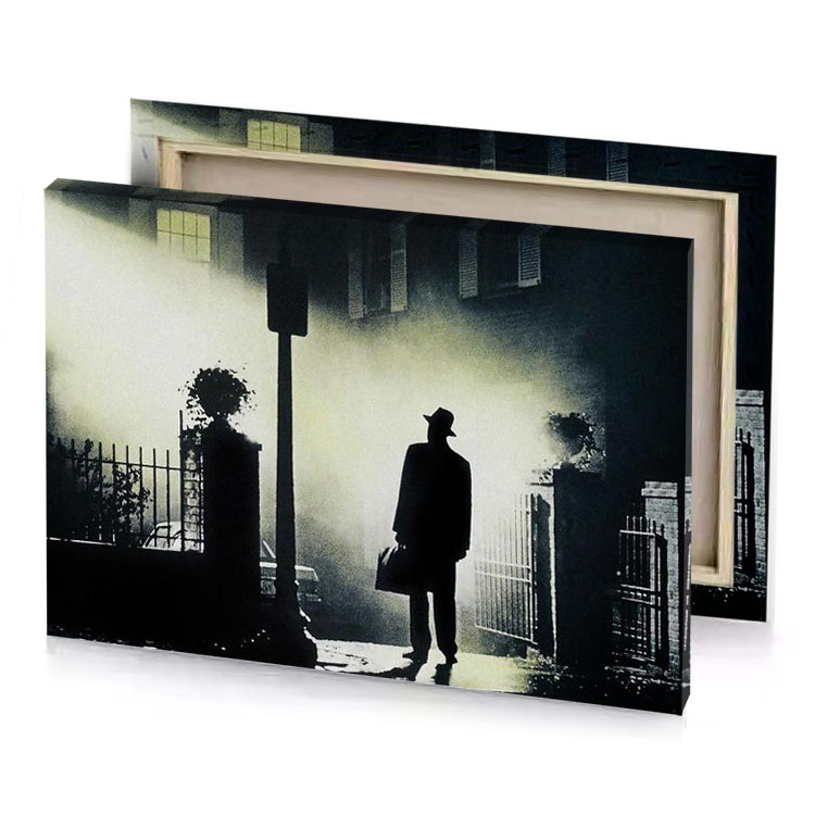 a man standing in the dark with light shining on silver canvas
