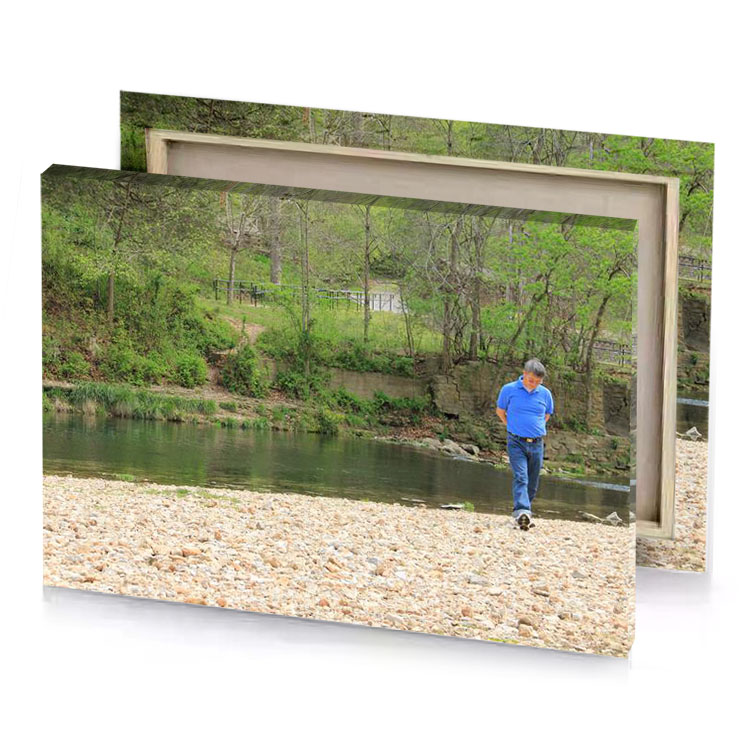 a man standing on rocky shore next to river dark olive green canvas