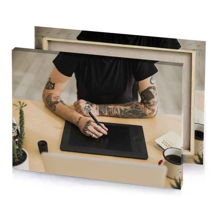 a man with tattoos sitting at table laptop smoky black canvas