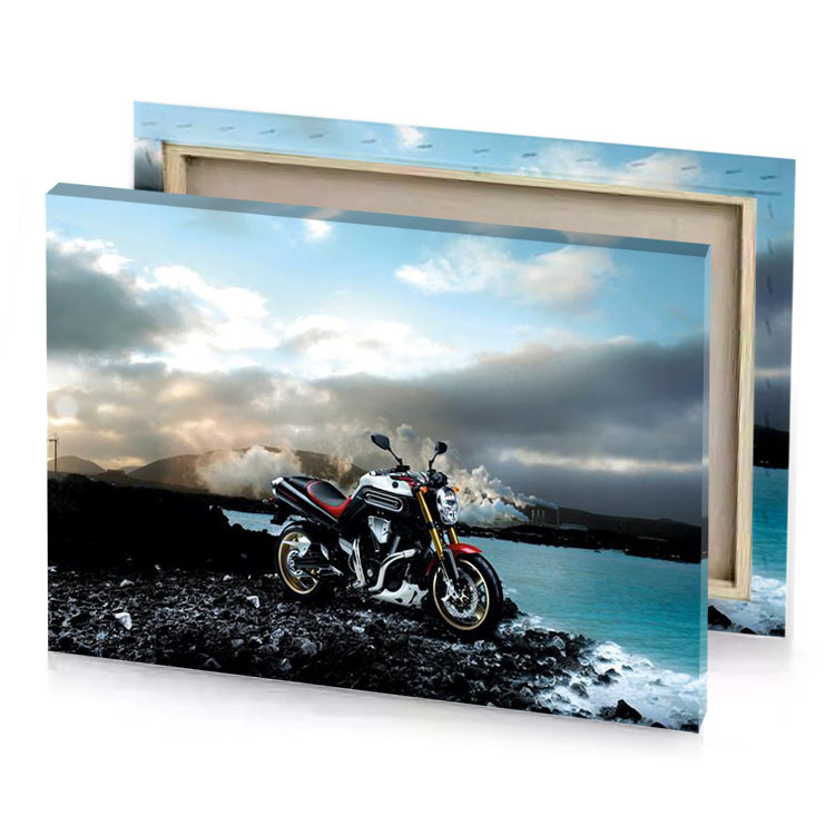 a motorcycle parked on rocky shore next to the ocean silver canvas