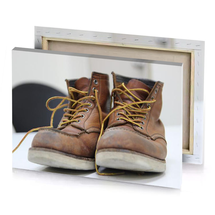 a pair of brown leather boots with yellow laces camouflage green canvas