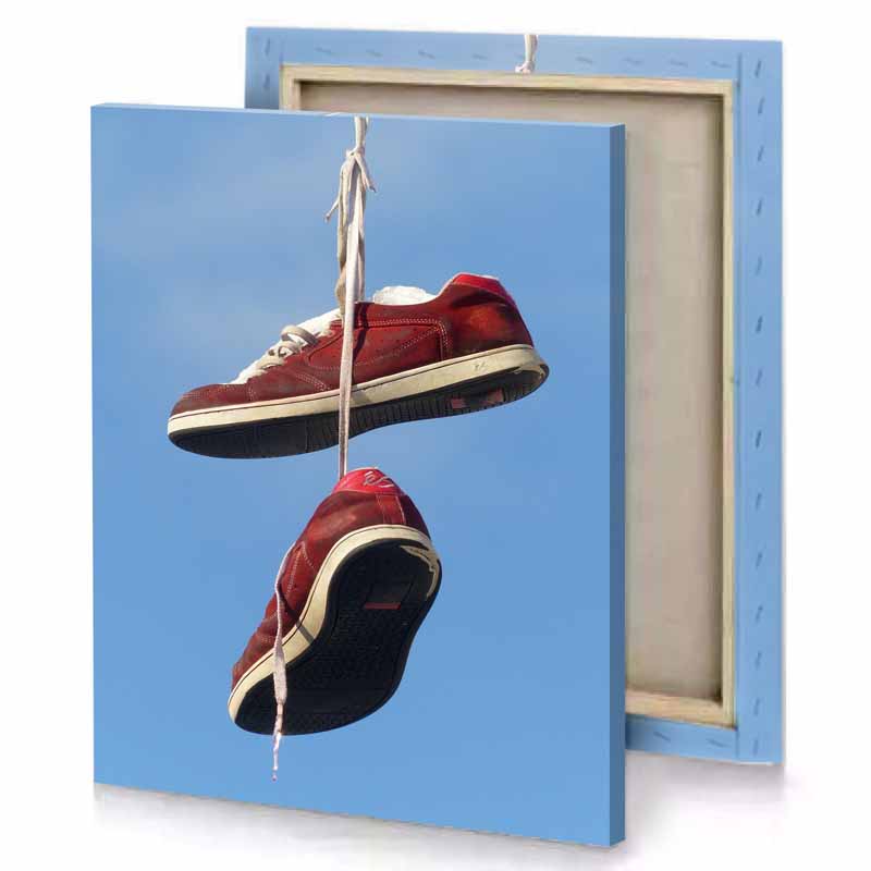 a pair of red shoes hanging from string garnet canvas