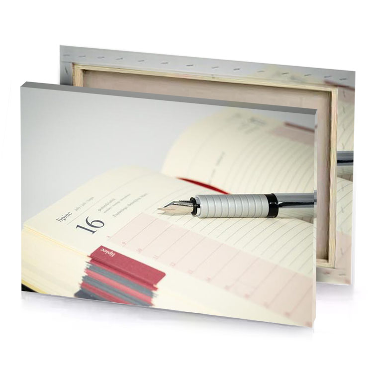 a pen resting on notebook with stack of books in eggshell canvas