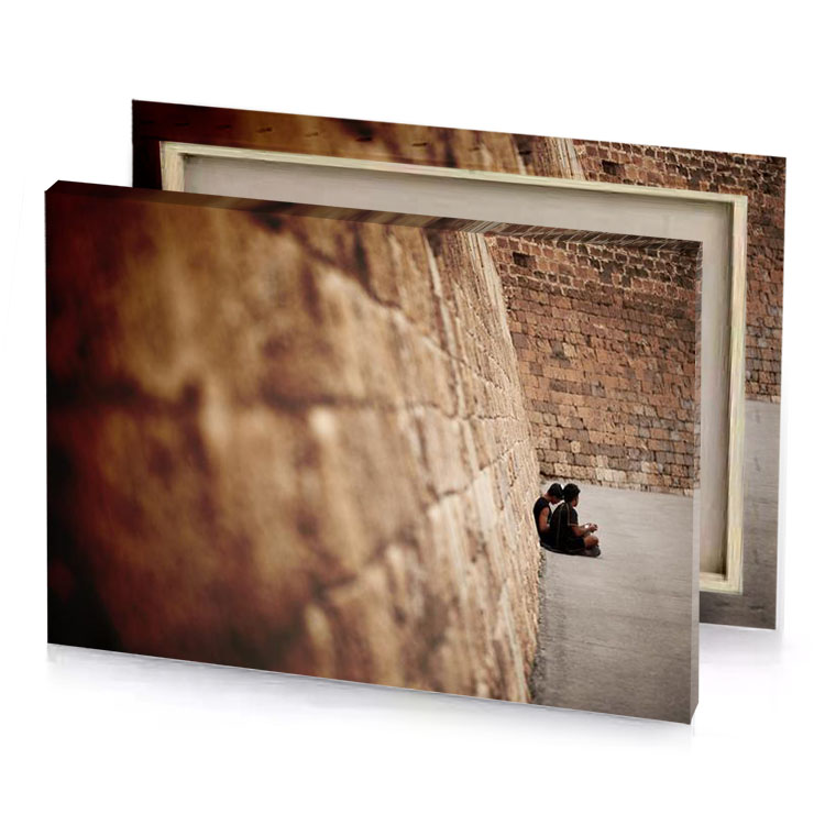 a person sitting on ledge in brick wall tan canvas
