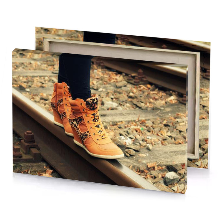 a person standing on train track with their shoes sand brown canvas