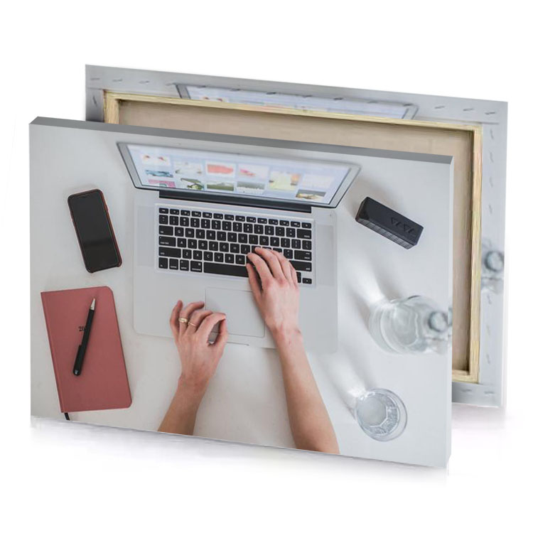 a person typing on laptop with pen and cup of rosy brown canvas