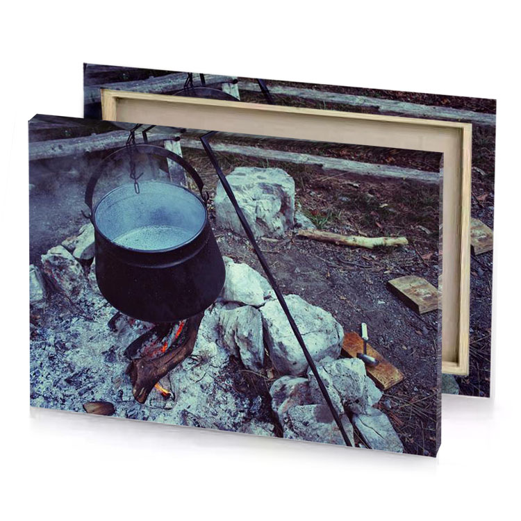 a pot is cooking over fire in field silver canvas