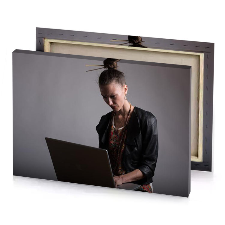 a woman sitting on chair using laptop gray canvas