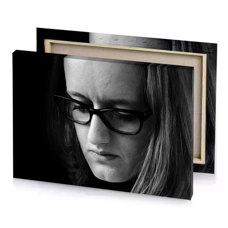 a woman with glasses looking down at her phone smoky black canvas