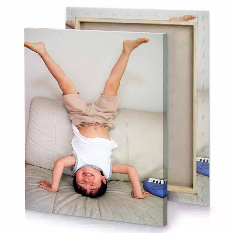 a young boy laying on couch with his arms up tan canvas