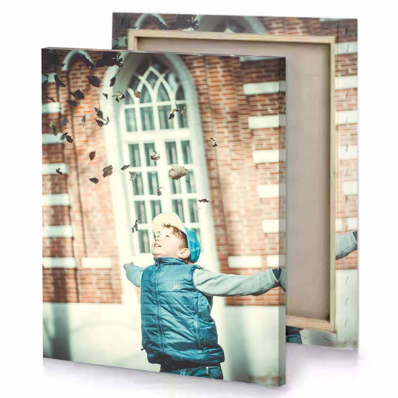a young boy throwing leaves in the air beige canvas