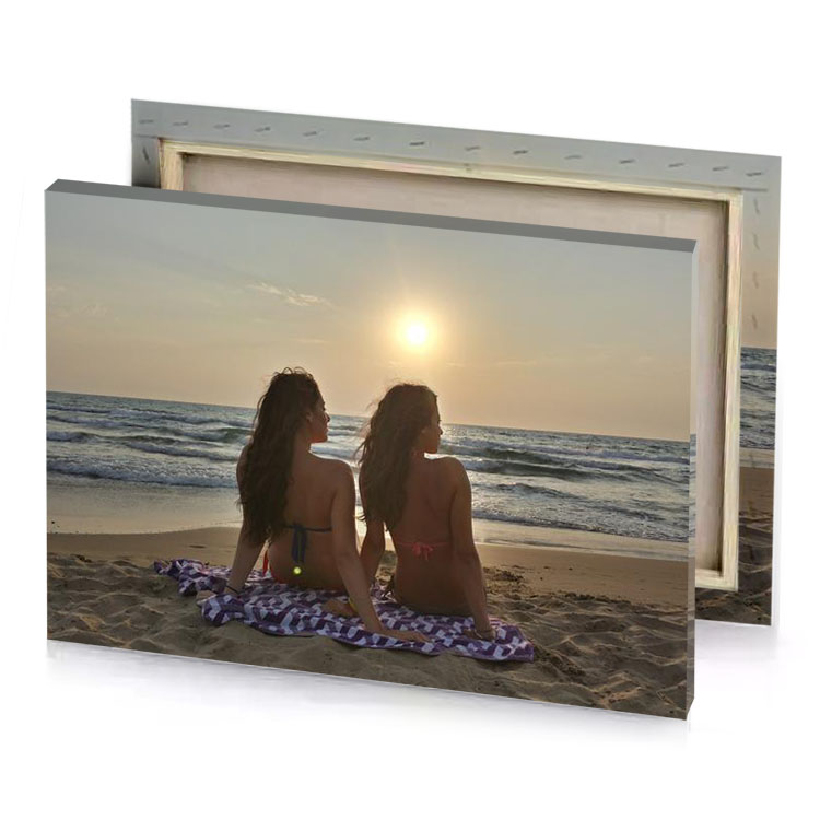 two girls sitting on the beach watching sun tan canvas