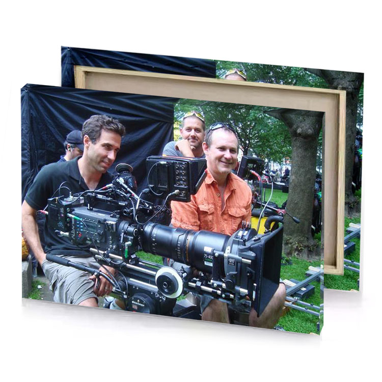 two men are sitting on a bench with camera charcoal canvas