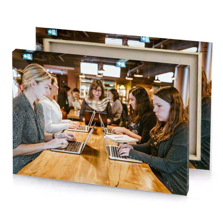 two women sitting at a table with laptops bistre canvas